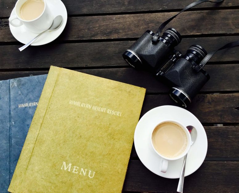 Photo of menu cards presented next to coffe cup.