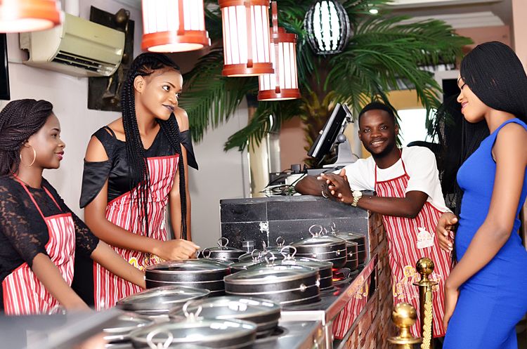 Waiters serving food to customer in restaurant.